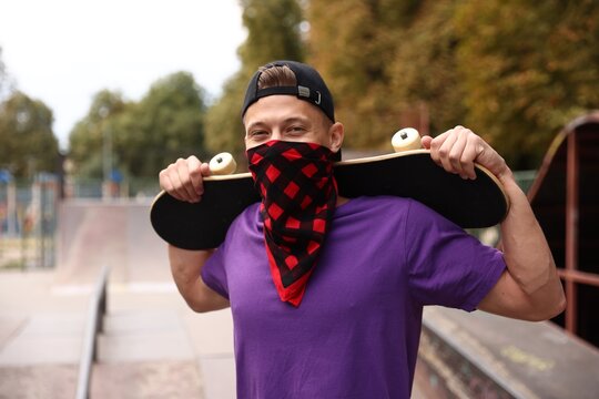Stylish man with skateboard in skate park