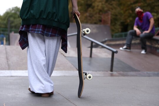 Woman with skateboard in skate park, closeup