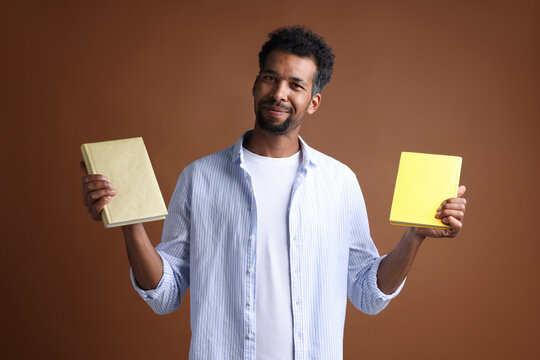 Man choosing between two books on brown background