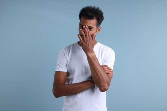 Choice. Portrait of thoughtful man on light blue background