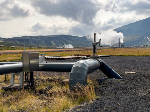 View of Svartsengi Geothermal Power Plant with industrial piping and steam rising against a volcanic landscape in Grindavik, Grindavikurbaer, Iceland.