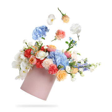 Beautiful flowers and box with bouquet flying in air against white background