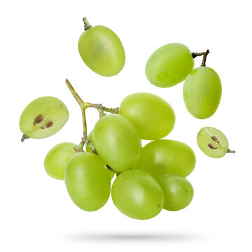 Green grapes flying in air against white background