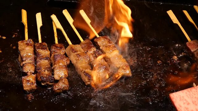 Japanese Aburi Teppanyaki Kushiyaki of flame searing on meat skewers
