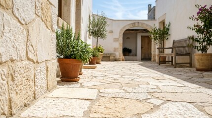 Naklejka premium Mediterranean patio with textured limestone flagstones and potted plants, bright natural light, creating a serene outdoor oasis with copy space