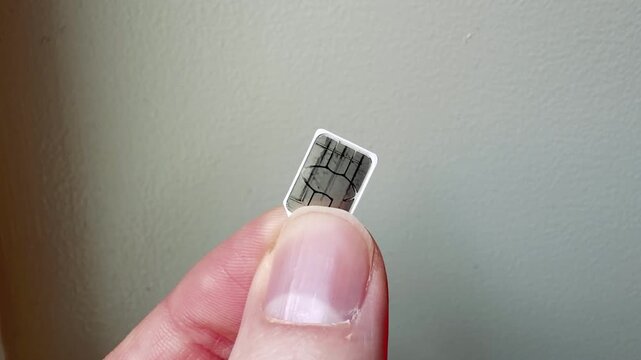 Physical Sim Card Held Between Fingers Close-up