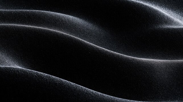 Textured dark surface with subtle, undulating waves catching light