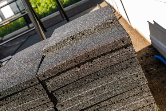 Stacked rubber flooring tiles with visible connector holes