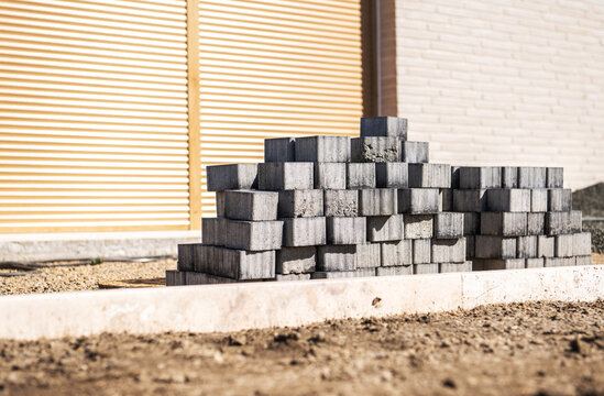 Stacked paving blocks beside a house with closed shutters