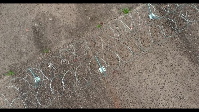 Descending overhead view toward a razor wire support bracket