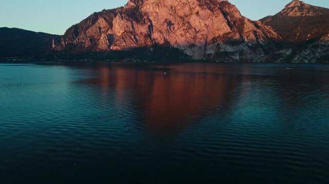 Aerial view of Mount Traunstein peak reveal over Lake Traunsee at sunset
