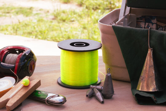 Fishing equipment displayed on a rustic wooden surface, highlighting essential tools such as lines and a reel ready for a day of outdoor fishing.