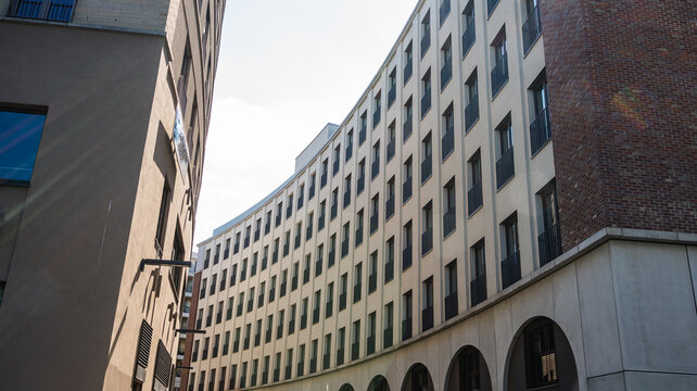 Modern white building facade with repeating windows. Minimalist urban architecture background. Perspective view of contemporary corporate or residential exterior, selective focus, shifted horizon, bac