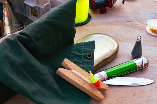 Fishing equipment close up with various tackle items, including lines, bobbers, and a reel, ready for a relaxing outdoor fishing trip.
