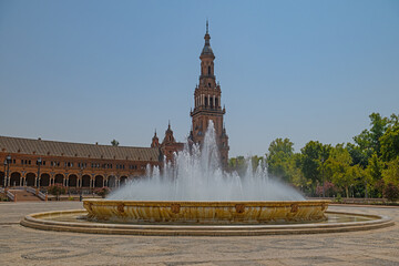 A fountain water show rising in the spacious Plaza de España in Seville, with the historic tower in the background. © TAMER YILMAZ
