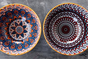 Obraz premium Two ceramic bowls combine concentric red pattern with orange floral design.