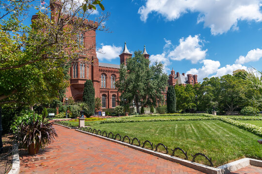 Landscaped gardens frame the historic red Smithsonian Castle in Washington, DC.