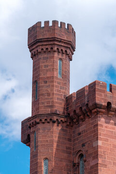 Historic Smithsonian Castle turret rises beneath summer clouds in Washington, DC.