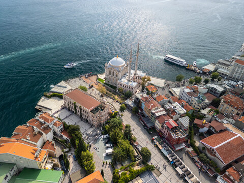 Turkey, Istanbul 01 10 2025: Drone photo of Buyuk Mecidiye Mosque in Ortakoy with Esma Sultan Yali, ferry terminal, kumpir street and boats on Bosphorus sea.