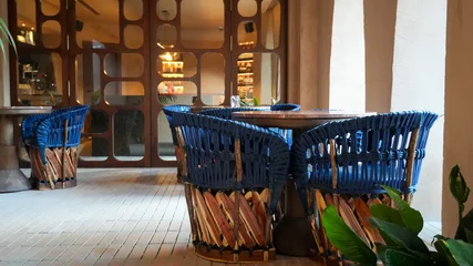 Fotobehang Horeca Empty outdoor restaurant patio with blue wicker chairs and wood tables  © F#ck yeah! Go you!