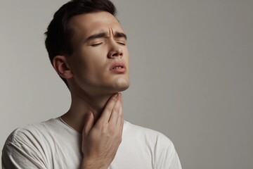 Obraz premium Young man coughs while holding his throat in a plain setting Generative AI