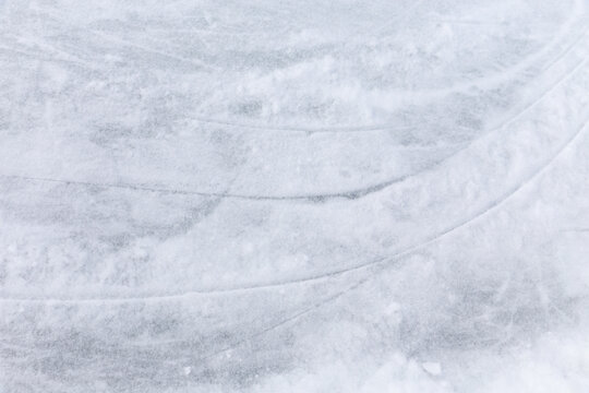Ice background with marks from skating and hockey, blue texture of rink surface with many scratches