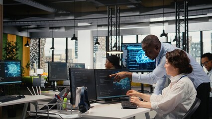 Manager supervises an intern in a startup office using artificial intelligence for market...