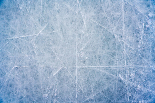 Ice background with marks from skating and hockey, blue texture of rink surface with scratches