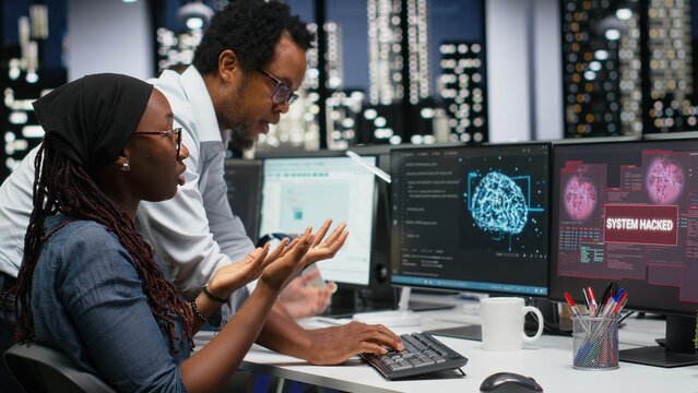 Programmers work together in an office to block a hacker intrusion, coordinating cybersecurity incident response against scammer attacks as a team.