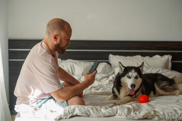 Man photographing a husky with its tongue out © iwavephoto