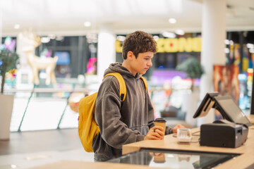 Obraz premium Teenage boy ordering at a food court counter