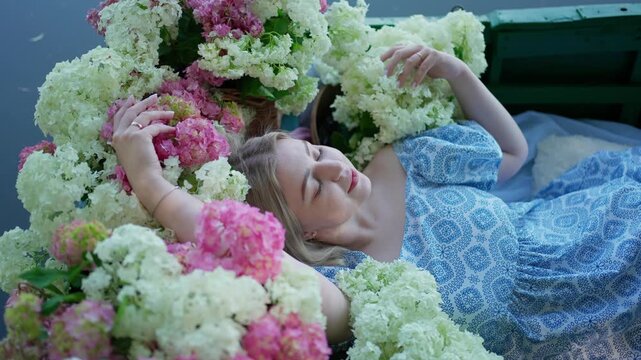 Young woman posing among hydrangeas in a boat. Concept romantic atmosphere.
