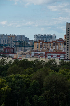 Modern city skyline panorama with residential apartment buildings under blue sky.
