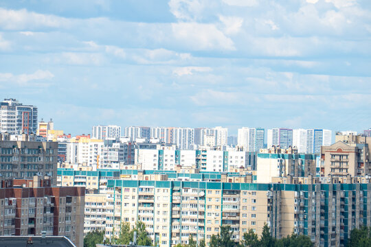 Modern city skyline panorama with residential apartment buildings under blue sky.
