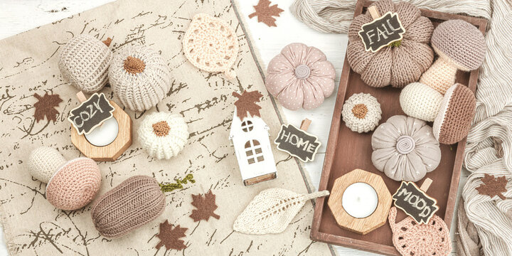 Cozy autumn mood composition. Handmade decor for home, traditional fall symbols - knitted props