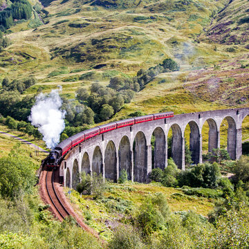 Aerial view of a Jacobite steam train crossing Glenfinnan viaduct, Highlands, Scotland, UK