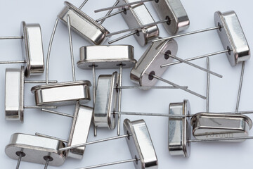 Silver radio transistors lie scattered on a plain white surface
