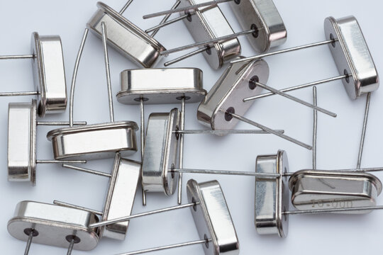 Silver radio transistors lie scattered on a plain white surface