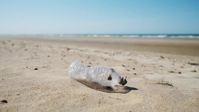Plastic bottle on the beach. Plastic trash buried in the sand. Environmental waste problem on the sea coast.