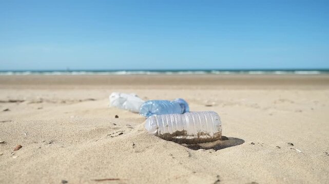 Plastic bottle on the beach. Plastic trash buried in the sand. Environmental waste problem on the sea coast.
