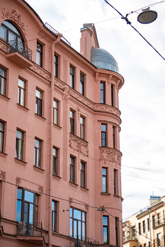 Classic historic building stone facade with art nouveau ornaments and windows pattern close up.
