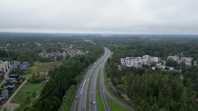 Aerial drone view of the highway intersection of Ring I and Tuusulanv&auml;yl&auml; in the Patola and Pakila area of Helsinki, Finland, with cars and traffic visible on the roads during summer.