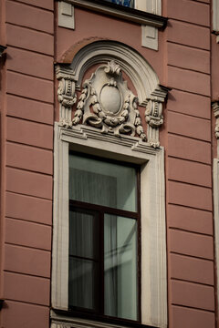 Classic historic building stone facade with art nouveau ornaments and windows pattern close up.

