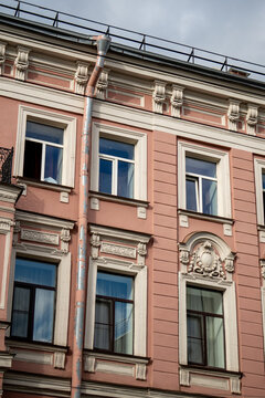 Classic historic building stone facade with art nouveau ornaments and windows pattern close up.
