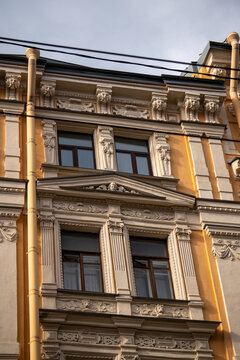 Classic historic building stone facade with art nouveau ornaments and windows pattern close up.
