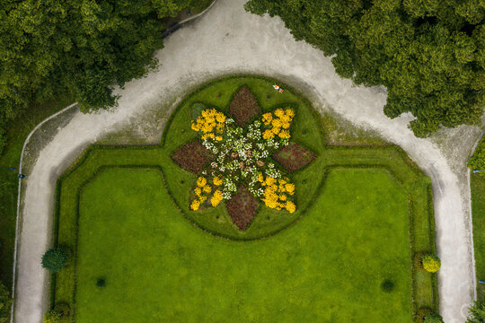 Aerial view of the formal star-shaped flower bed at Traku Voke Manor, surrounded by manicured lawns, gravel paths, and lush green trees in Vilnius, Vilniaus apskritis, Lithuania.