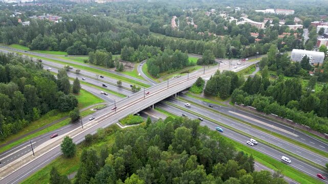 aerial drone video of Maunula in Helsinki, Finland, featuring a highway with moving cars, residential buildings, green areas, and the surrounding Nordic cityscape during summer.