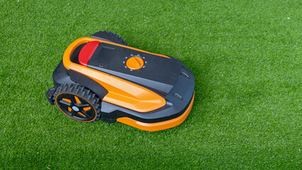 Fototapeta premium Small Autonomous Robot Mower Machine at Grass in Garden
