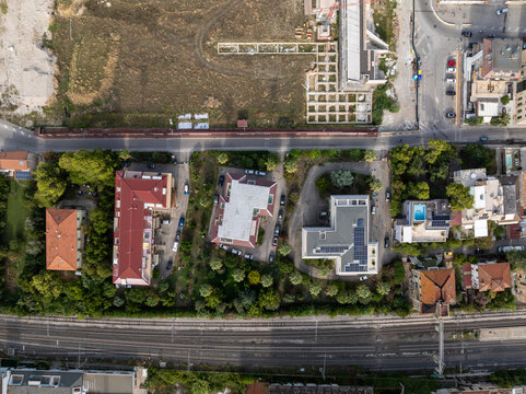 Aerial view of the historic Ex Stadio Fratelli Ballarin site with its red perimeter wall, surrounded by residential buildings and railway tracks in San Benedetto del Tronto, Marche, Italy.