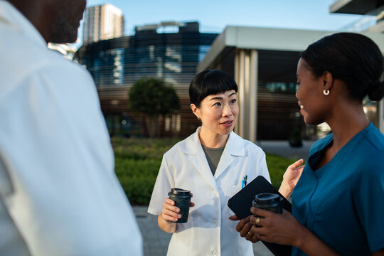 Doctors and nurse talking outside hospital on coffee break